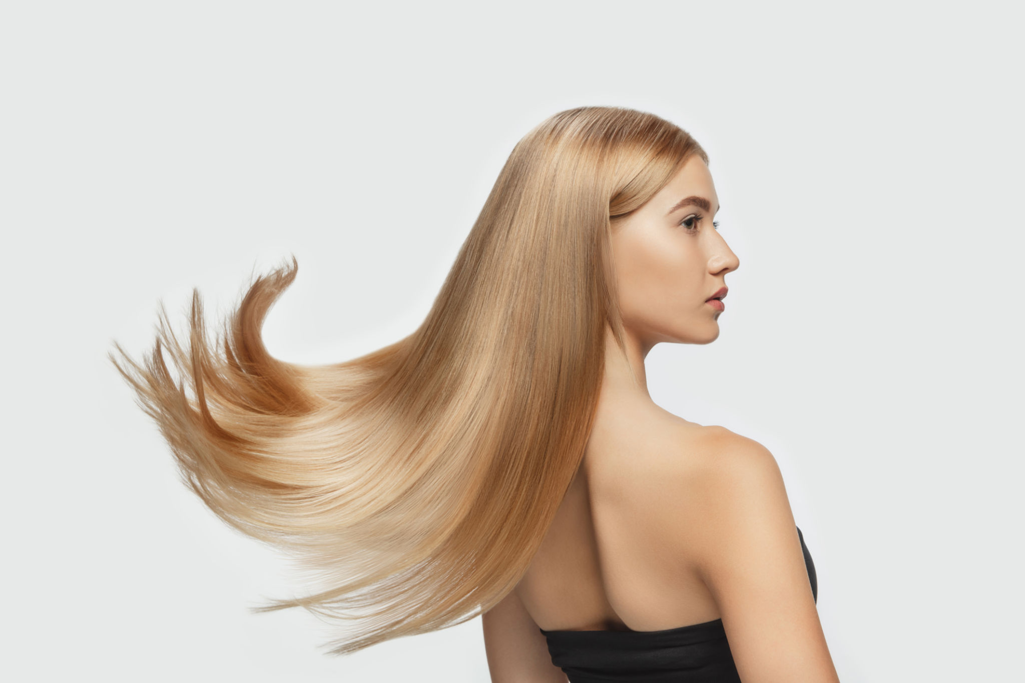 Beautiful model with long smooth, flying blonde hair isolated on white studio background. Beautiful model with long smooth, flying blonde hair isolated on white studio background.