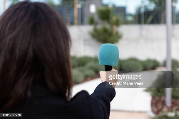 close-up of a hand of a journalist holding a microphone - stock photo - hand microphone stock pictures, royalty-free photos & images