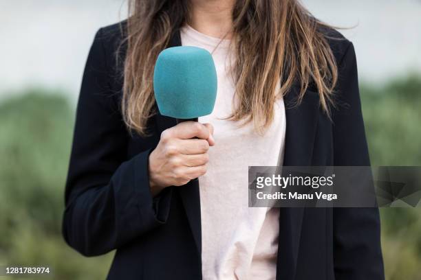 close-up of journalist woman holding a microphone - stock photo - apresentador de noticiário - fotografias e filmes do acervo