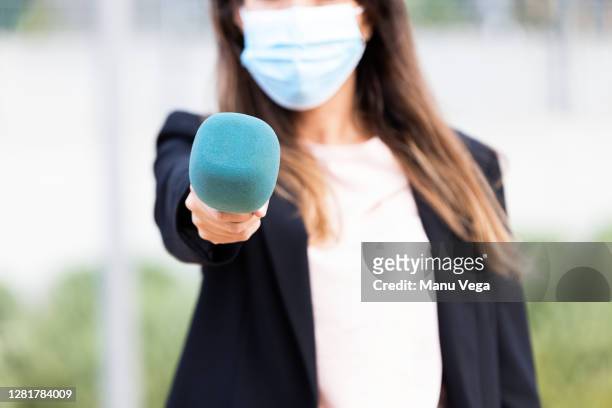 journalist wearing a medical mask on the street - stock photo - tv reporter street stock pictures, royalty-free photos & images