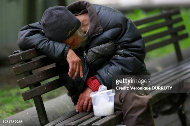 Sans abri sur un banc dans le Parc Kronvalda, 16 mai 2018, Riga, Lettonie.