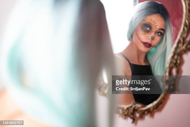 mädchen mit halloween make-up schauen sich in den spiegel - halloween zombie makeup stock-fotos und bilder