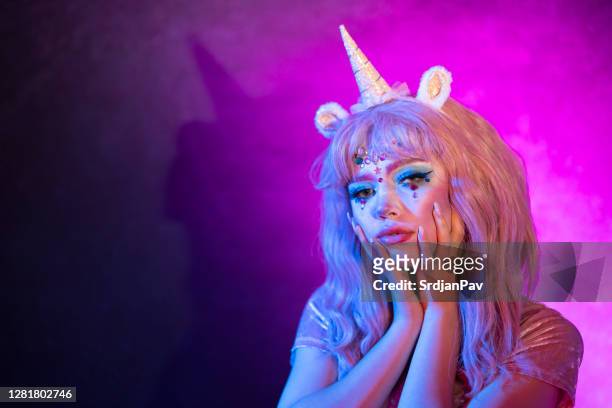 portrait of a said girl in a beautiful unicorn halloween costume. - unicorn stock pictures, royalty-free photos & images