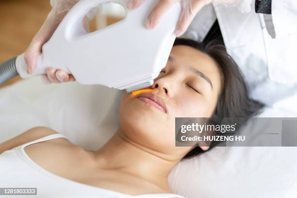 laser epilation. woman soft skin care. young woman in a beauty salon - laser face stock pictures, royalty-free photos & images