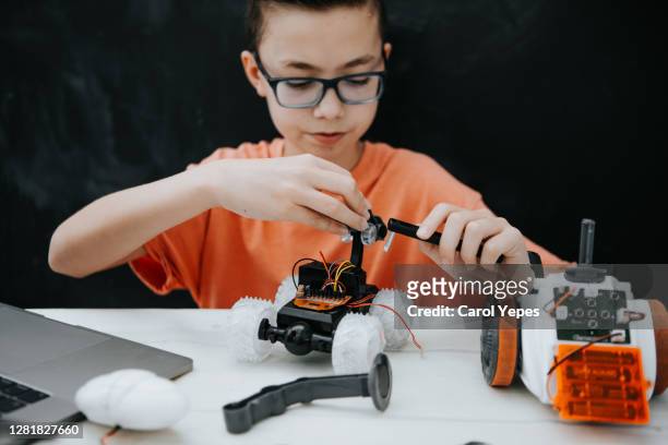 teen boy building robotic car for school assignment - kids instruments fotografías e imágenes de stock