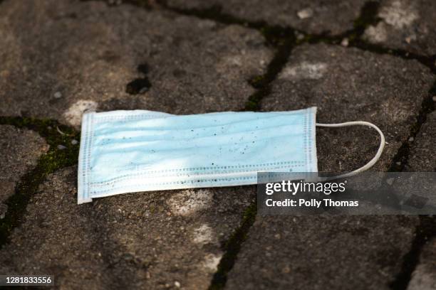 Discarded surgical face mask on the pavement on October 23, 2020 in Cardiff, Wales. Wales will go into a national lockdown from Friday until November...