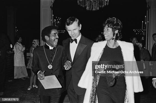 From left to right, American entertainer Sammy Davis Jr, television host Johnny Carson and entertainer Altovise Davis at the Beverly Hilton in...