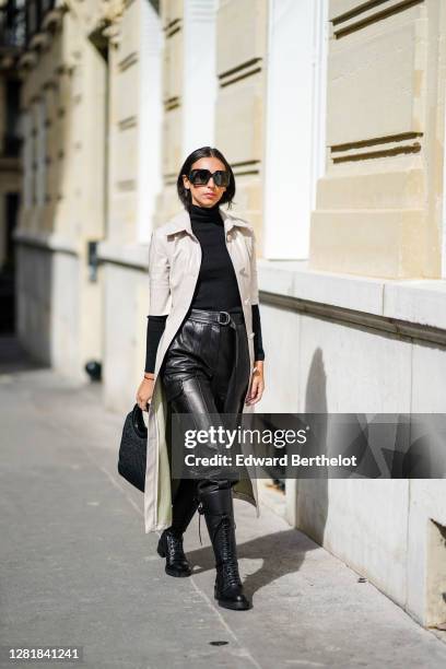 Gabriella Berdugo wears a total look from Barbara Bui, black leather trousers with maxi pockets, black turtleneck knit pullover, black high soldier...