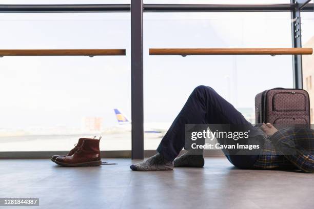 passenger lying near window in airport - jet lag stockfoto's en -beelden