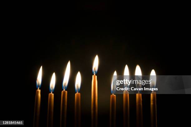 close-up of burning golden hanukah candles - menorah fotografías e imágenes de stock