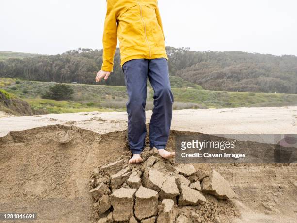detail of young person standing on crumbling edge of sandy ledge - tween heels stock pictures, royalty-free photos & images