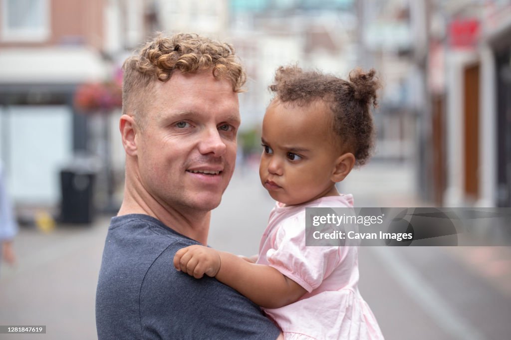 A red head father holding his daughter