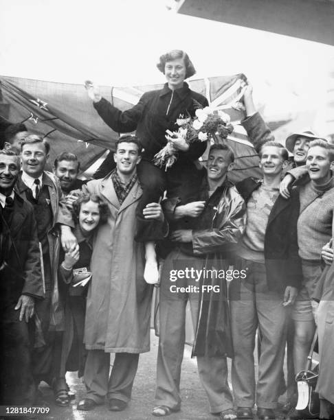 Yvette Williams of New Zealand is carried from the Olympic Stadium after winning the gold medal in the final of the women's long jump at the Summer...