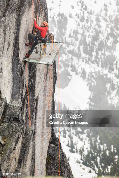 rock climber uses prusik to ascend cliff above portaledge. - ascender stock pictures, royalty-free photos & images