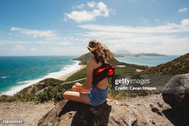 girl looks out over the caribbean and atlantic ocean stunning views - saint kitts and nevis stock pictures, royalty-free photos & images