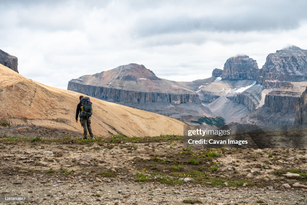 Hiker Observing Remote Mountain Peaks in Distance