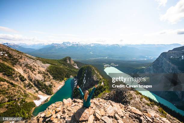 hiker celebrating above lake louise and lake agnes on devil's thumb - victoria canada stock-fotos und bilder