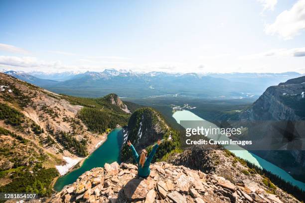 hiker celebrating above lake louise and lake agnes on devil's thumb - victoria canada fotografías e imágenes de stock