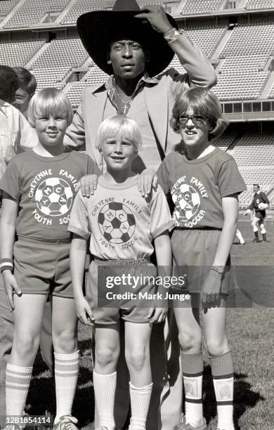 Former standout player Pele poses with three young soccer players Andy Junge, Dan Junge and Jeff Nesheim from Cheyenne, Wyoming during a soccer game...