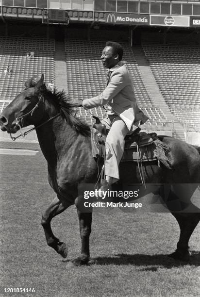 Former standout player Pele rides a horse across the Mile High Stadium playing field. Pele was feted during a soccer game between the Colorado...