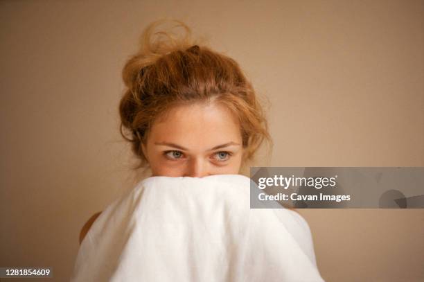 young woman covers her face with a blanket close-up of the face. - woman pillow over head stock pictures, royalty-free photos & images