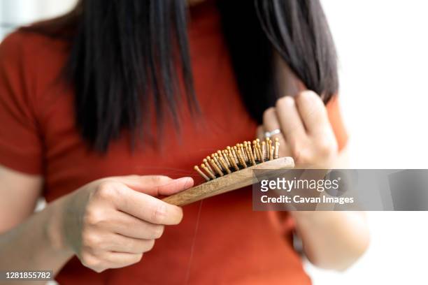 long loss hair fall on woman brush with and woman looking at her - kalend stockfoto's en -beelden