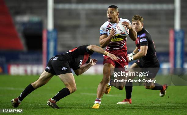 Willie Isa of Wigan is tackled by Elliot Kear of Salford during the Betfred Super League match between Wigan Warriors and Salford Red Devils at...
