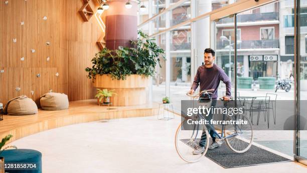 pendler, die in die bürolobby kommen - business fahrrad stock-fotos und bilder