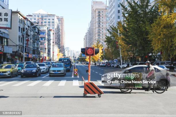 Vehicles and people are seen in a street on October 23, 2020 in Dandong, Liaoning Province of China.