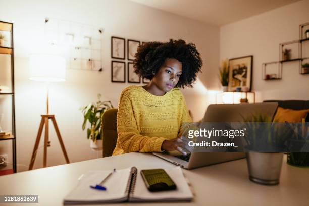 giovane imprenditrice afroamericana all'home office, che lavora fino a tardi - adulto foto e immagini stock