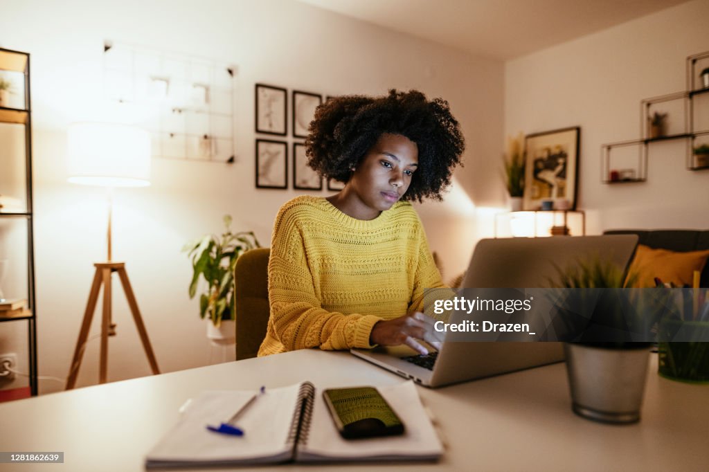 Young African American businesswoman at home office, working late