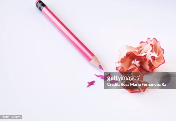 pink pencil with sharpening shavings on white background. - pencil sharpener stock-fotos und bilder