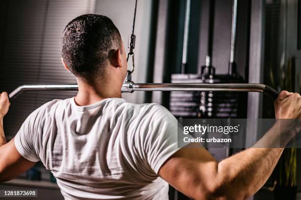 work out on pulldown weight machine - pull down workout stock pictures, royalty-free photos & images