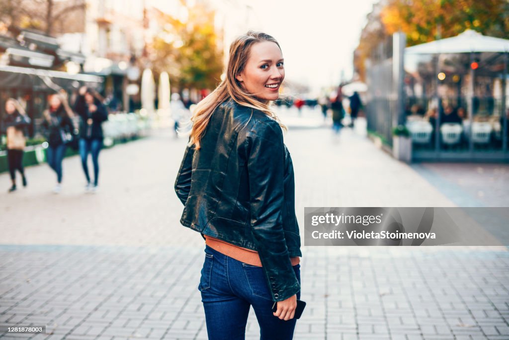 Cheerful woman walking in the city.