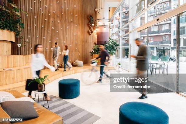 pendler, die in die bürolobby kommen - bewegungsunschärfe büro stock-fotos und bilder