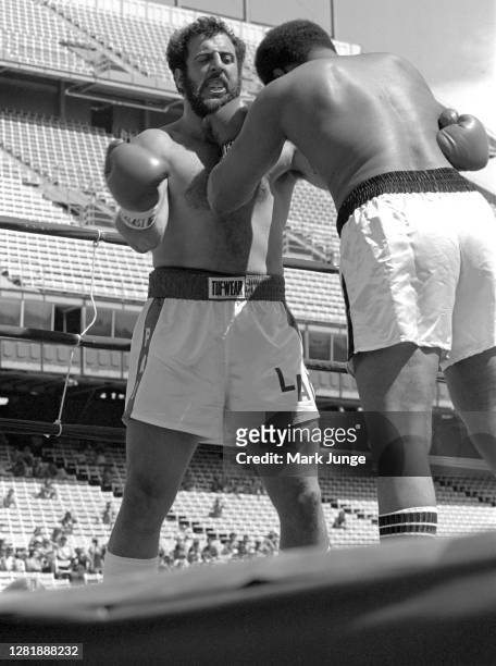 Lyle Alzado , goes into a clinch against Muhammad Ali during an eight-round exhibition match at Mile High Stadium on July 14, 1979 in Denver,...