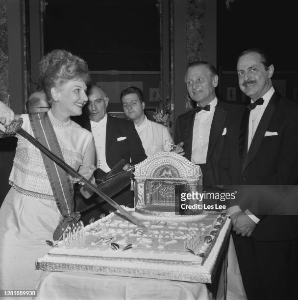 American actress and singer Mary Martin cuts her birthday cake, a representation of a Drury Lane theatre, at a party for the cast of the show 'Hello,...