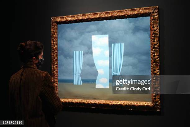 Person wearing a protective mask looks at "L'Ovation" by René Magritte during a press preview of the upcoming Impressionist and Modern Art Evening...