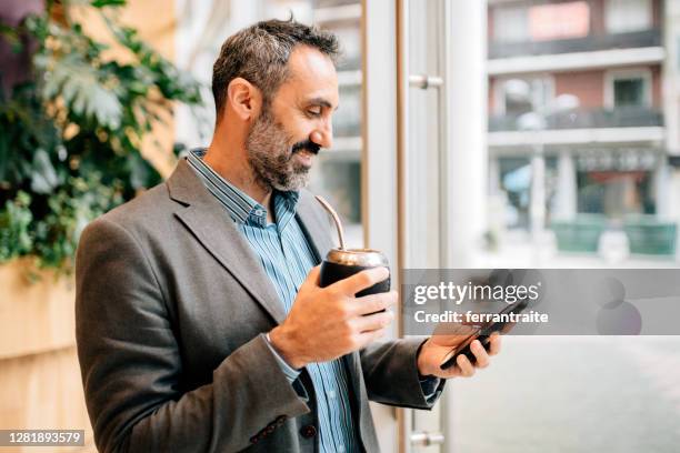 empresario usando el teléfono inteligente en el espacio de la oficina - yerba mate fotografías e imágenes de stock