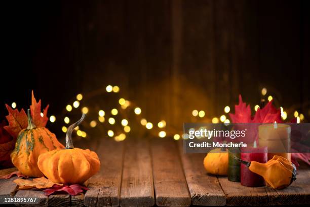 thanksgiving-dekoration mit kürbissen und grußkarte auf beleuchtetem hintergrund und einem rustikalen holztisch - harvest table stock-fotos und bilder