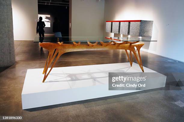 Person walks by Carlo Mollino's An Important and Unique Dining Table and Donald Judd's Untitled during a press preview of the upcoming Contemporary...