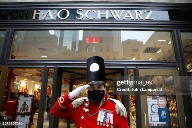 Man in costume wearing a face mask salutes as he poses in front of FAO Schwarz on October 23, 2020 in New York City. The pandemic has caused...