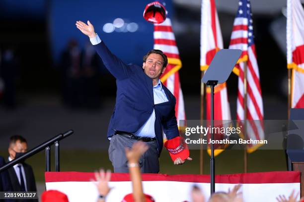 Florida Governor Ron DeSantis throws a hat to supporters during a rally for President Donald Trump on October 23, 2020 in Pensacola, Florida. With...