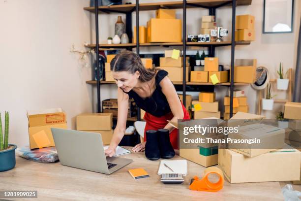 young woman unboxing online purchases in living room - returning customer stock pictures, royalty-free photos & images