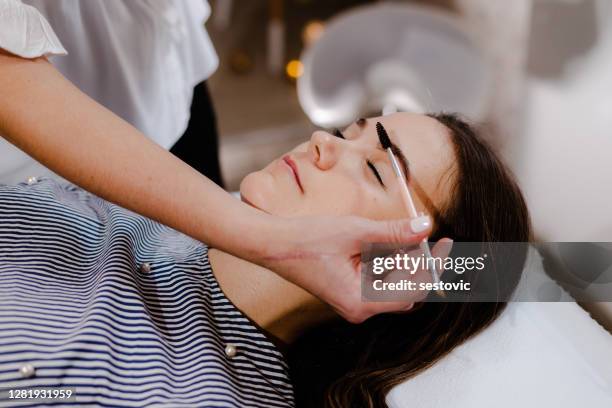 mujer joven en corrección de cejas en clínica de cosmetología - tatuaje de henna fotografías e imágenes de stock