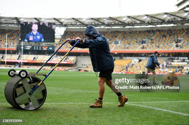 Ground staff are seen removing water from the field prior to the 2020 AFL Grand Final match between the Richmond Tigers and the Geelong Cats at The...