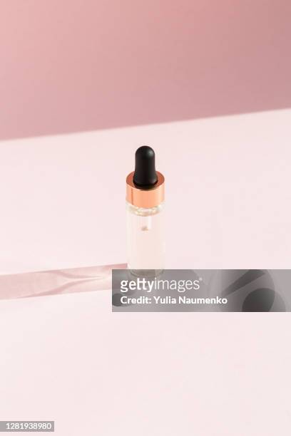 glass bottle with dropper on pink background. hard light, trends with hard shadows. - serum sample stock pictures, royalty-free photos & images