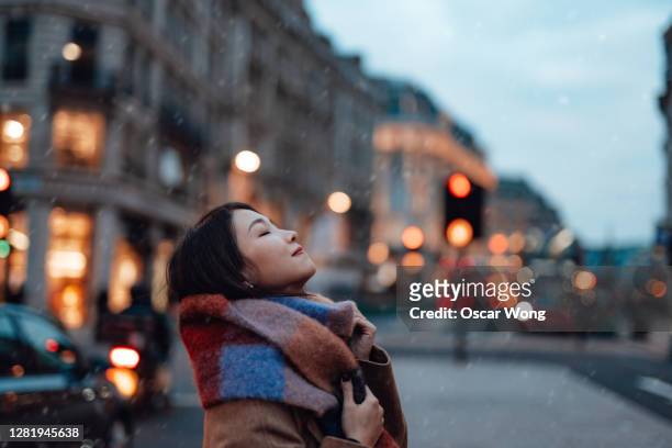 side portrait of young woman with scarf on the city street - daily life in london photos et images de collection