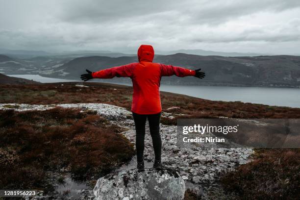 woman in red jacket with arms outstretched - moor stock pictures, royalty-free photos & images