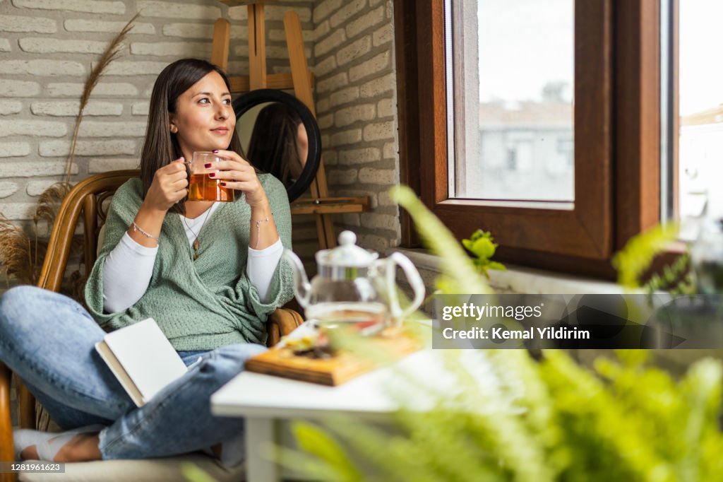 Young Woman drinking her winter tea and welcoming new day
